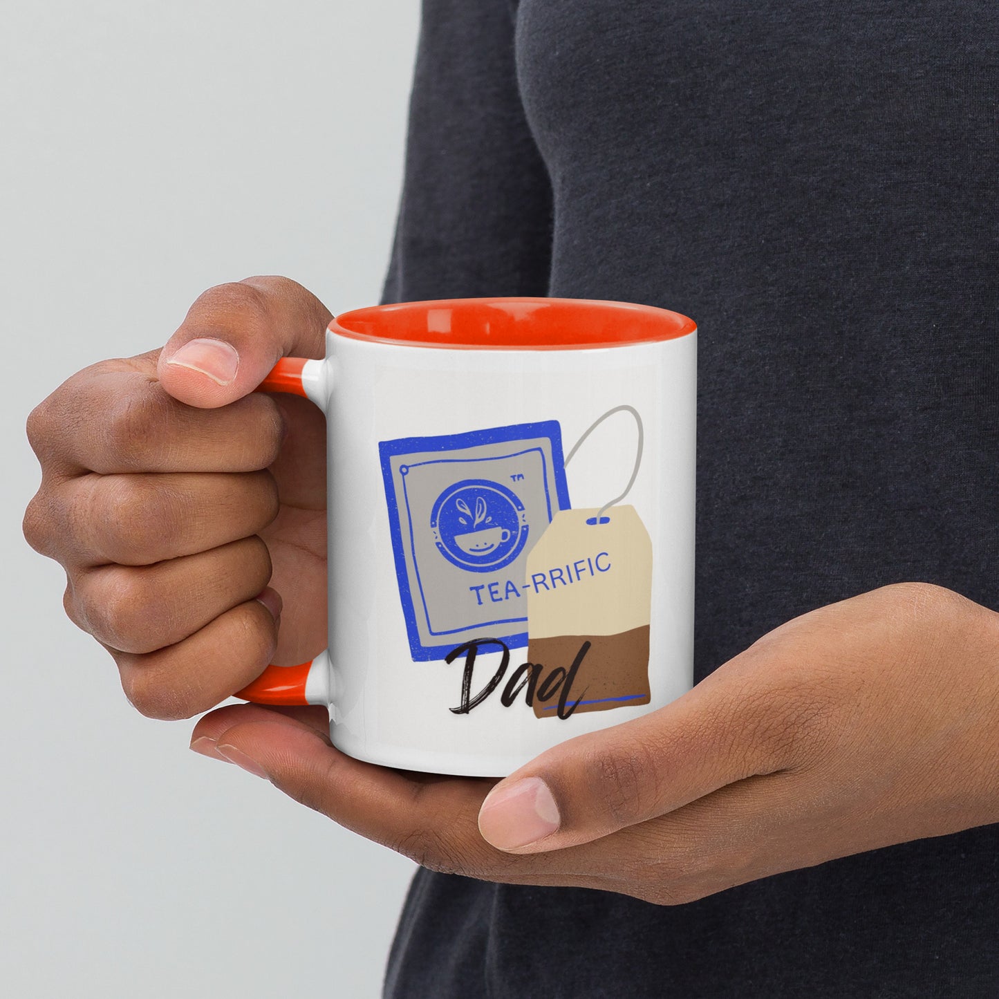 Person holding a mug with 'TEA-RRIFIC Dad' design on a plain White background.